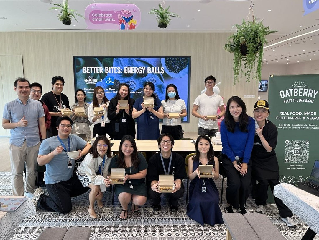 Team holding their handmade energy ball boxes after a wellness workshop in Singapore